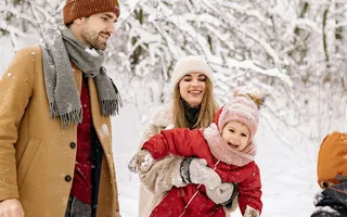 Eine Familie mit zwei Kindern spielt im Schnee