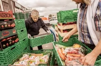 Zwei Personen arrangieren Kisten voller Lebensmittel