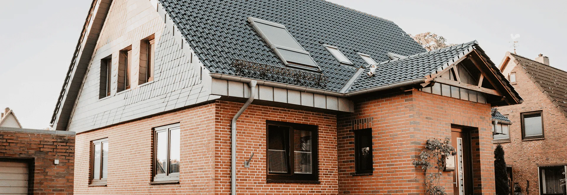 Typisch deutsches verklinkertes Einfamilienhaus mit schwarzem Dach.