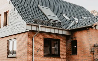 Typisch deutsches verklinkertes Einfamilienhaus mit schwarzem Dach.