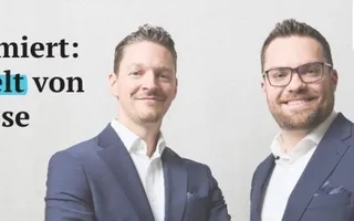 Geschäftsführer Sven Tippelt und Julian Grauer neben dem Slogan: "Bestens informiert: Die Maklerwelt von Adam Riese"