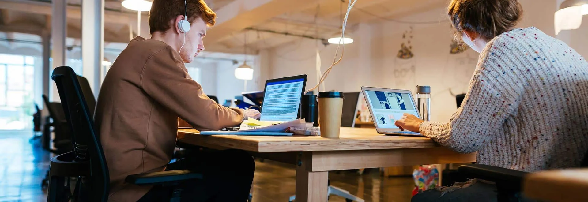 Zwei Personen arbeiten total konzentriert an ihren Laptops.
