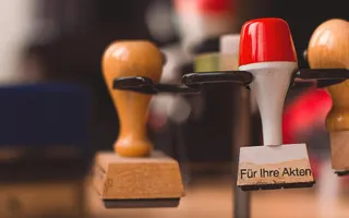 Rechtsschutz für Beamte kann sehr sinnvoll sein, auch wenn man vorrangig im Büro arbeitet: Ein Büroschreibtisch mit diversen Stempeln.