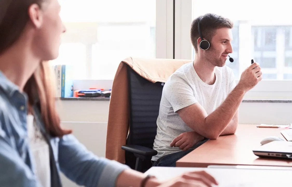 Mann mit Headset vor dem Bildschirm
