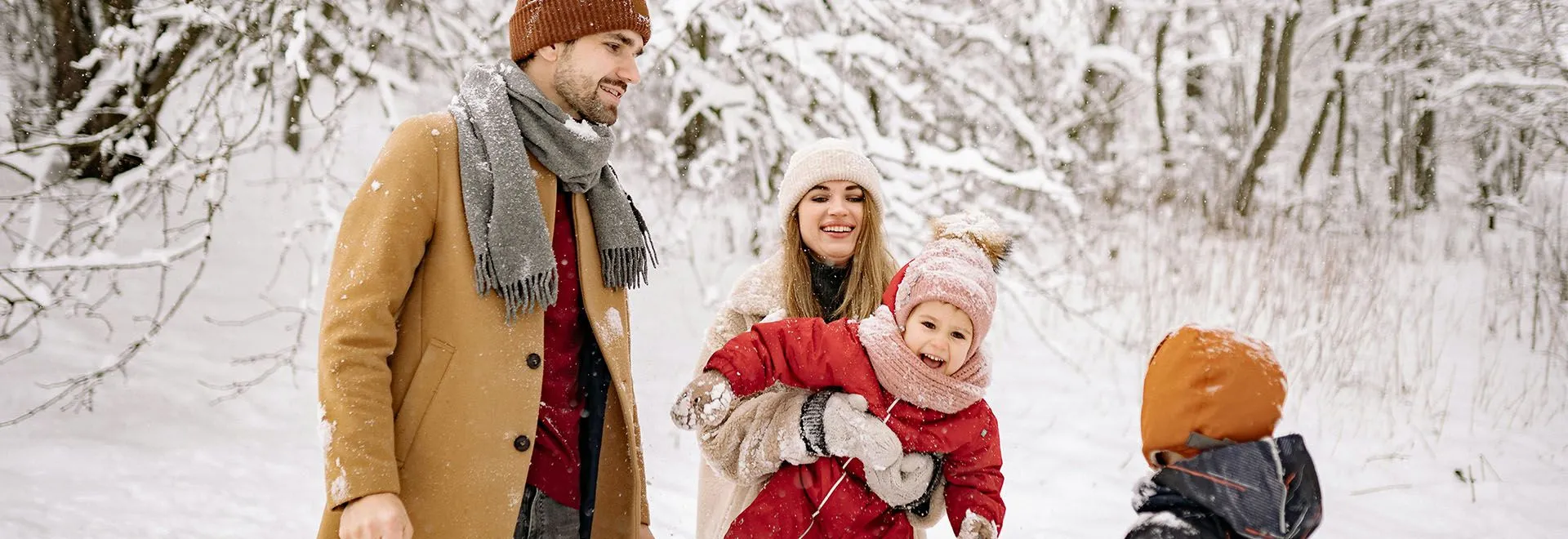 Eine Familie mit zwei Kindern spielt im Schnee