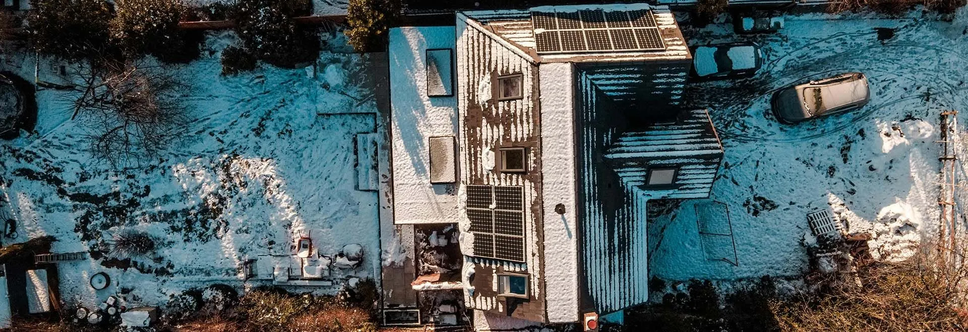 Ein winterliches Haus mit Garten aus der Vogelperspektive.