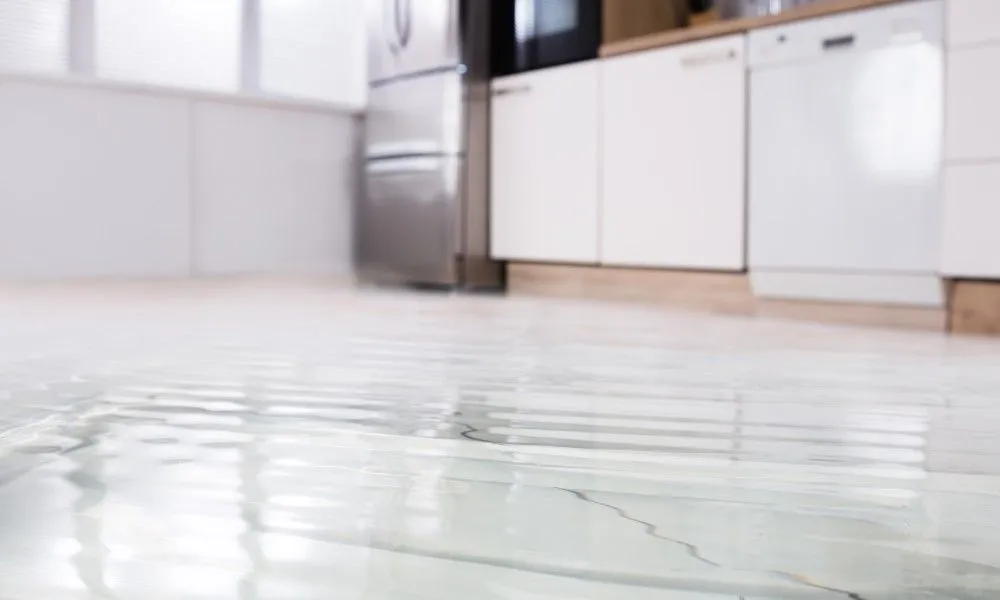 Wasser sammelt sich auf einem weißen Küchenboden.