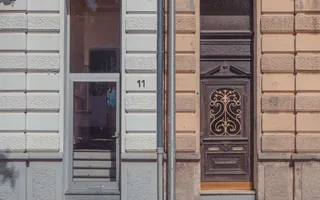 Ein Reihenhaus mit zwei unterschiedlichen Eingangstüren und Hauswänden.